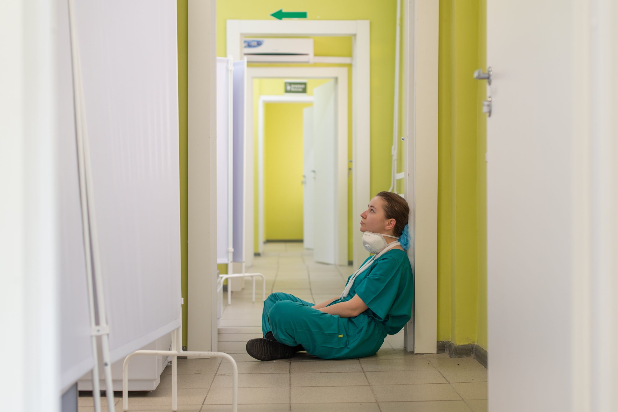 una metgessa cansada i asseguda al terra d'un hospital