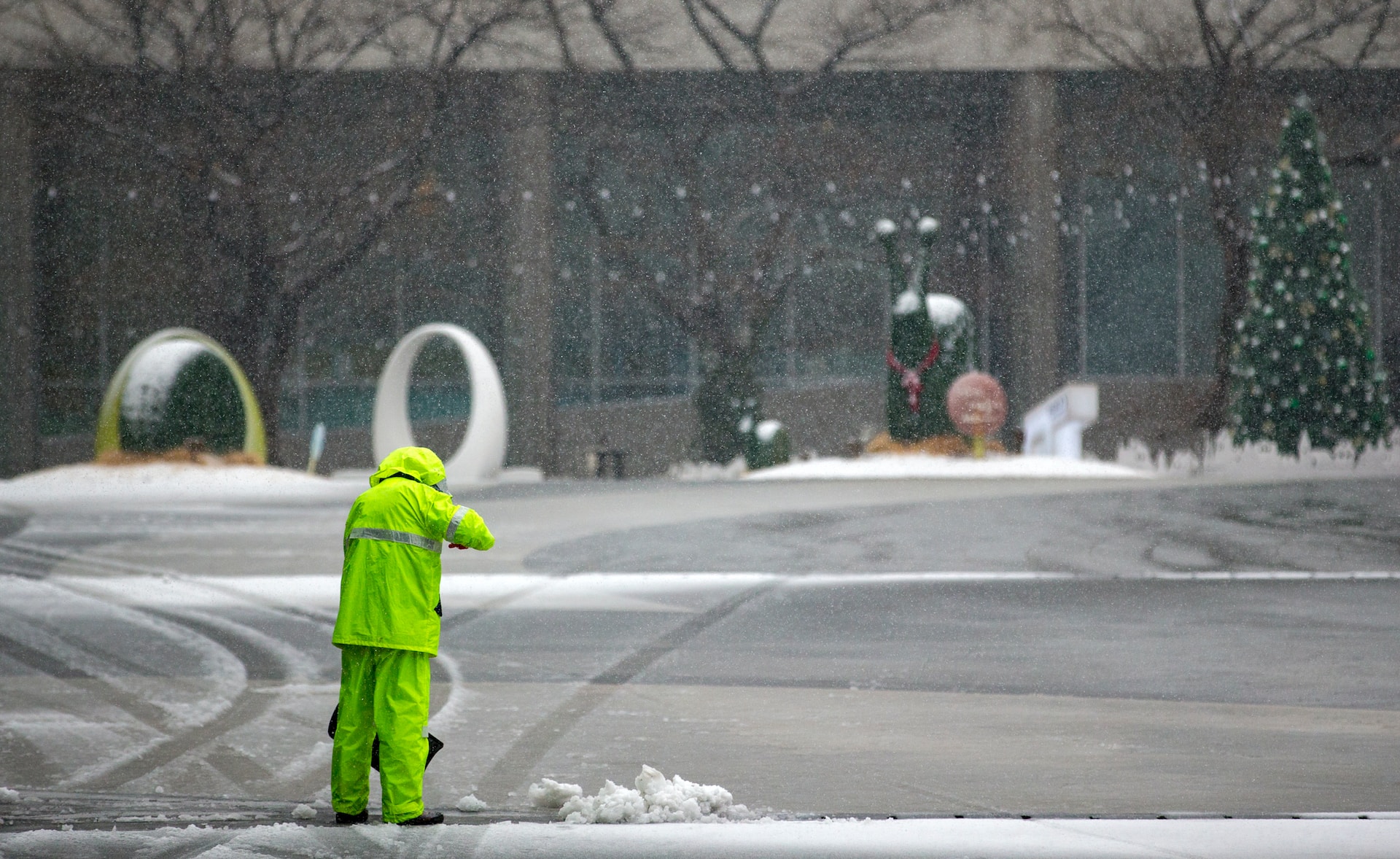 Un treballador de la neteja retirant neu d'una carretera