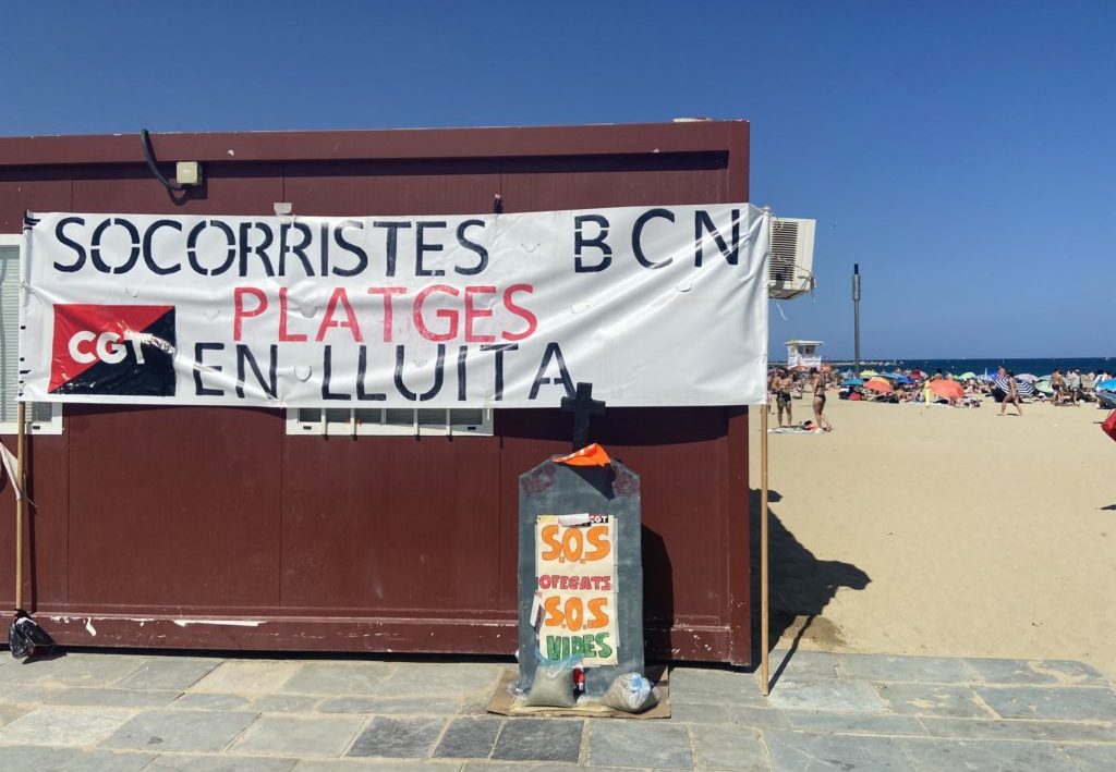 Un cartell de la vaga de socorristes de Barcelona a la platja
